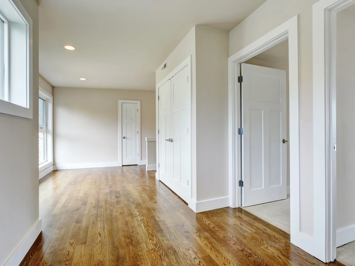 hallway-painting-empty-neutral-hallway-exeter-decorators Empty hallway with neutral walls, white doors and a wood floor